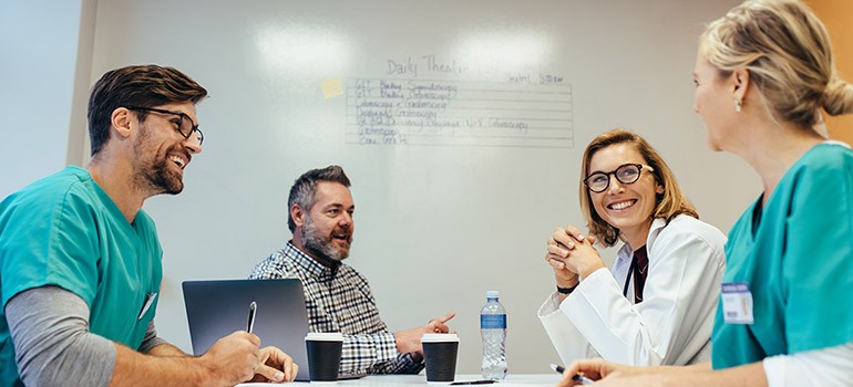 Doctors gathered around meeting table