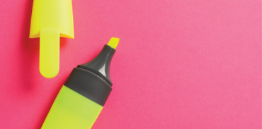 yellow highlighter with cap removed on a pink background