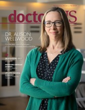 Dr. Alison Wellwood wearing black blouse and green sweater on the cover of the February 2023 edition of the doctorsNS magazine