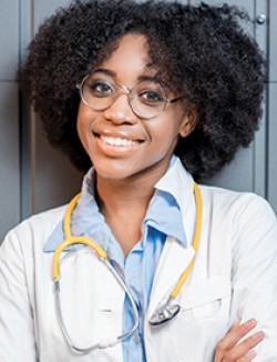 young female physician wearing light blue collared shirt, white coat and yellow stethoscope